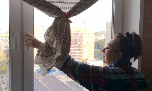 Женщина моет пластиковое окно