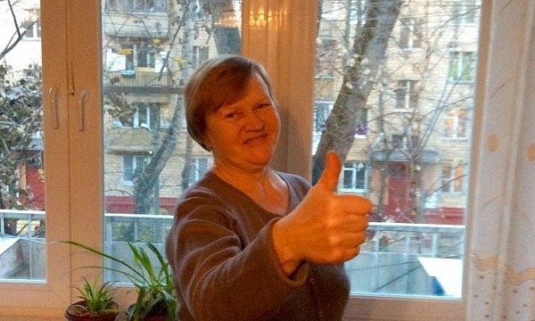 Женщина показывает большой палец вверх у окна