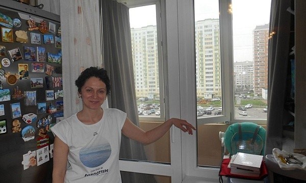 Женщина у окна во дворе Балашихи.