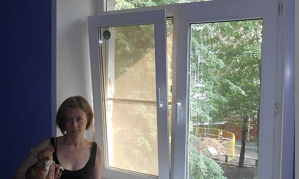 Женщина с собакой у пластикового окна