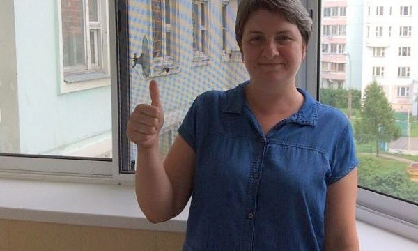 Женщина показывает палец вверх у окна