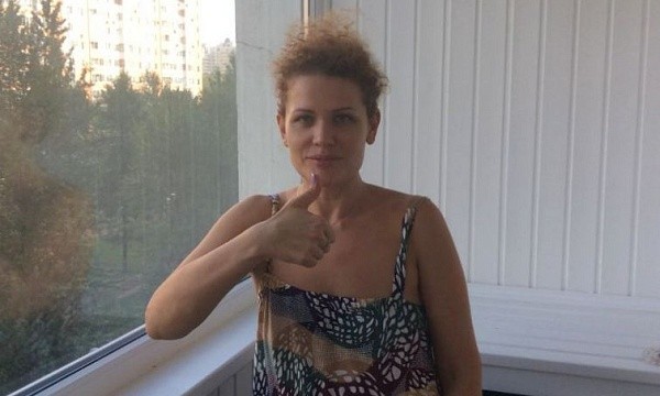 Женщина на балконе дает большой палец