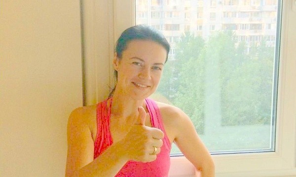 Женщина показывает большой палец у пластикового окна