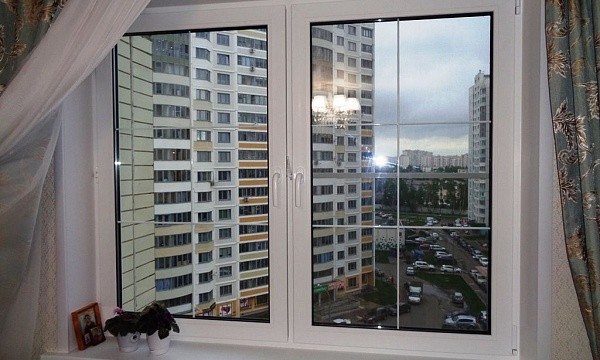 Двустворчатое белое окно с видом на многоэтажки