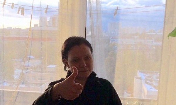 Женщина демонстрирует одобрение через окно.