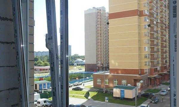 Пластиковое окно с видом на многоэтажный дом