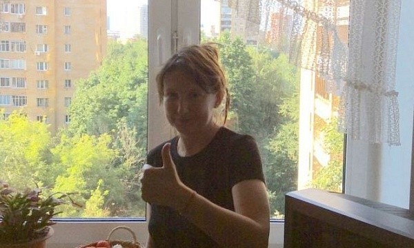Женщина с большим пальцем вверх у окна