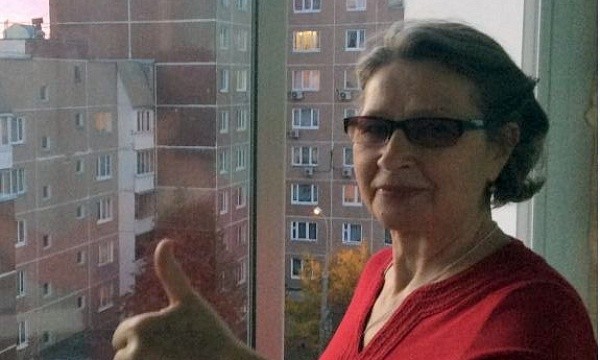 Женщина показывает большой палец у окна
