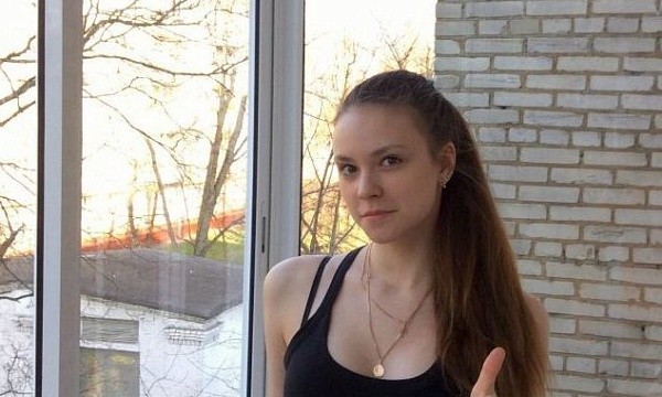 Девушка показывает большой палец вверх у окна