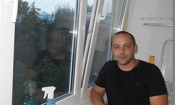 Мужчина с бутылкой моющего средства возле пластикового окна в Москве