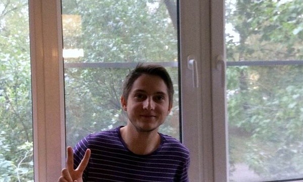 Мужчина показывает знак победы у окна